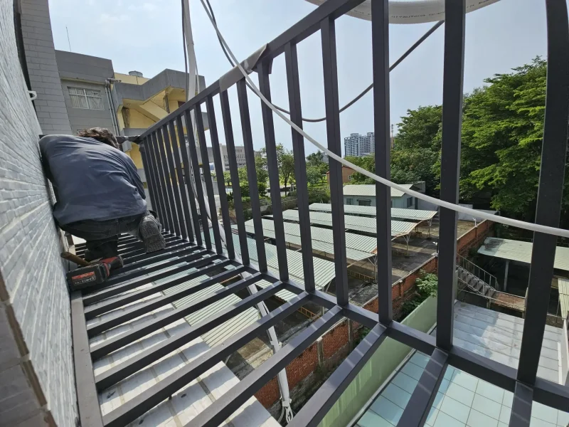 工程團隊在高樓外牆安裝空調護欄，重視安全防護