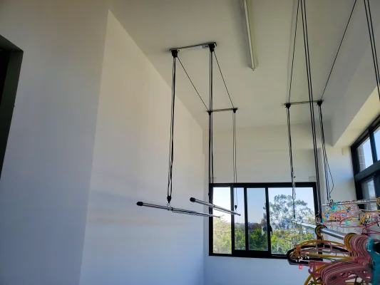 客戶家中兩組曬衣架的對比圖，一組拉繩有延長，一組拉繩簡潔俐落