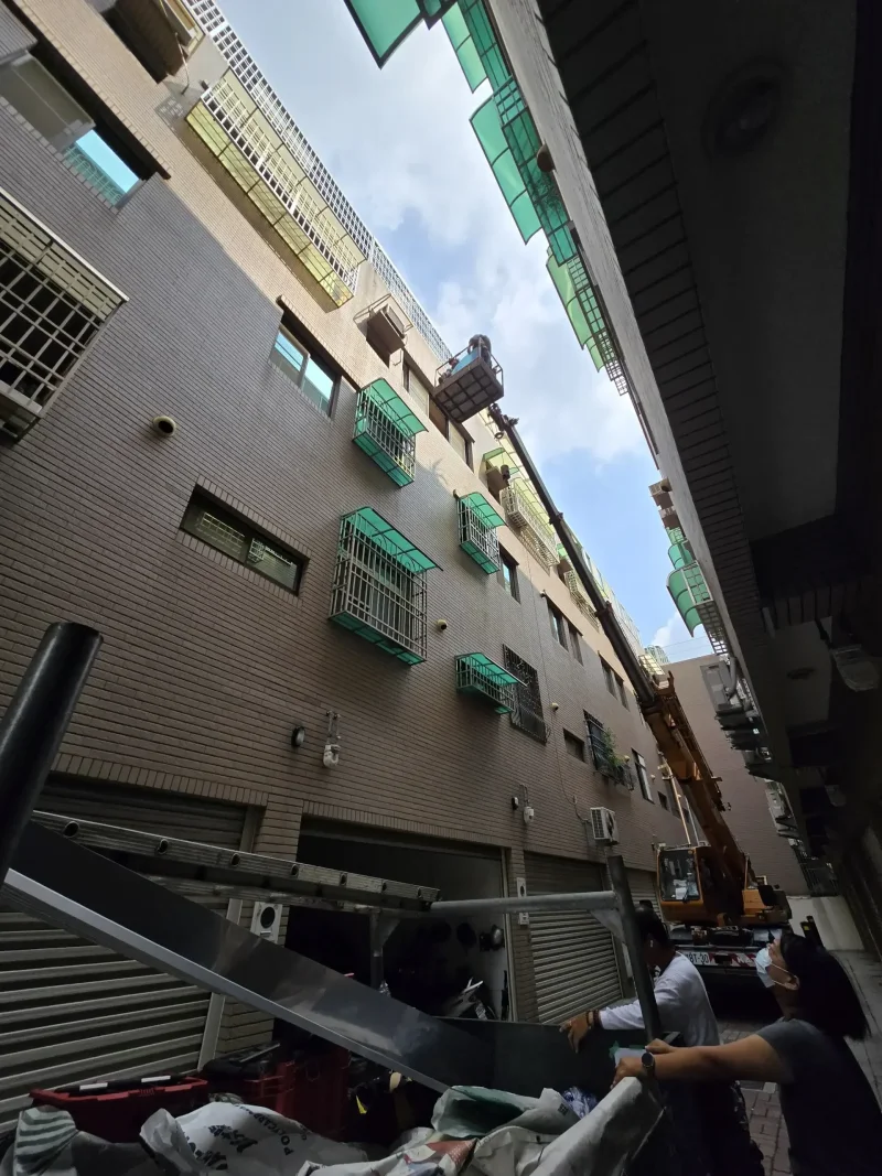 專業人員在高樓層進行雨遮PC板更換作業