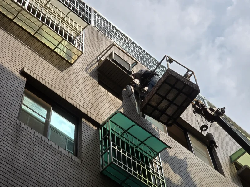 專業施工人員正在清理防盜窗鐵架骨架上的殘膠和鏽蝕