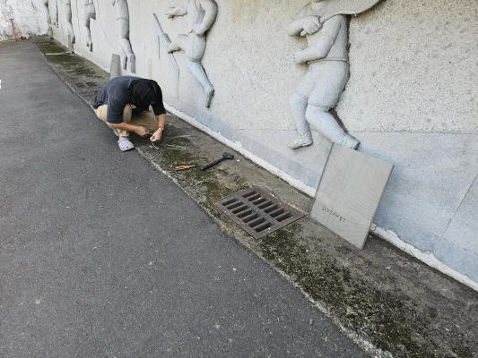 好室科技團隊在有坡度的車道上進行水溝蓋網安裝作業